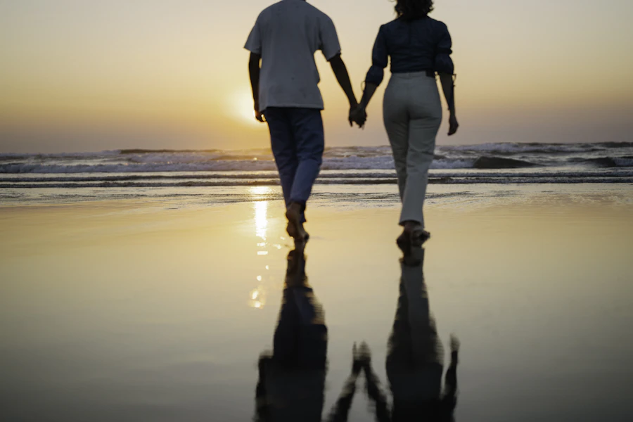 Couple walking hand in hand on the beach