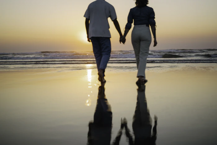 Couple walking hand in hand on the beach