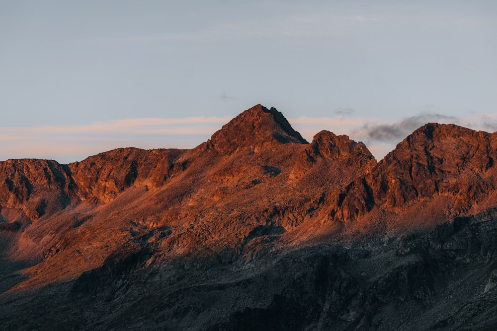 a rocky mountain with a cloudy sky