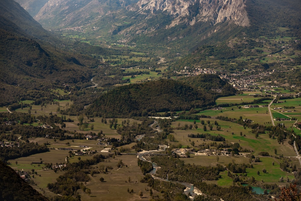 a valley with a river running through it and a town in the distance