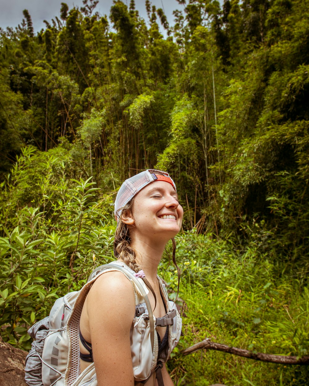 a woman smiling with trees in the background