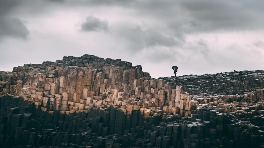 a person standing on a stone wall