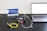 A setup involving a laptop connected to a black device with cables on a perforated black surface. There are colorful cables including yellow and green. A small pink object is placed nearby. A sign with the text 'CivilLaser' and a web address is in the background.