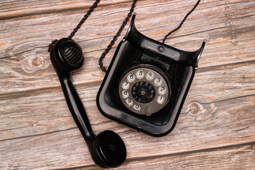 a black telephone on a wooden surface