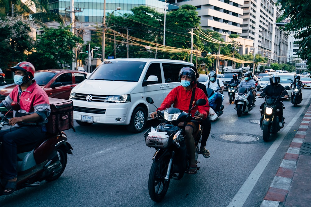 a group of people ride motorcycles down a street