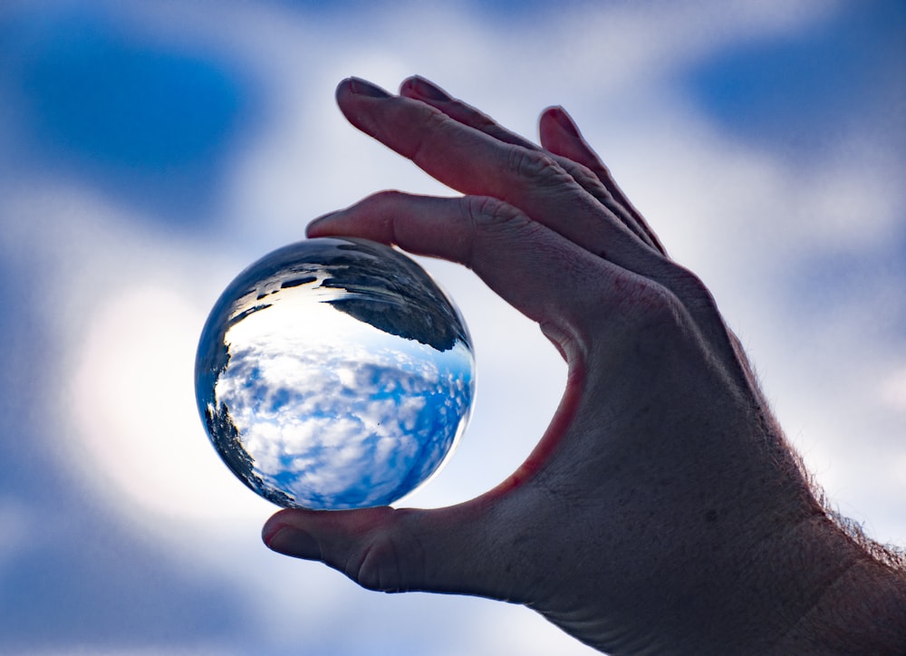 a hand holding a globe