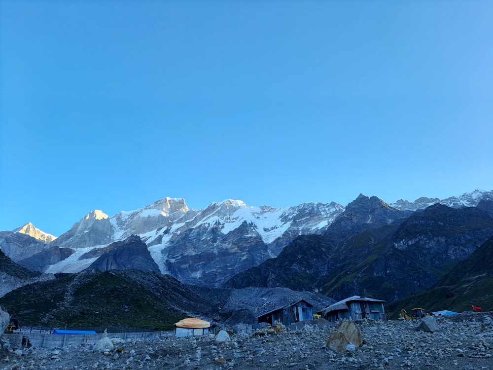 a group of houses in front of a mountain range
