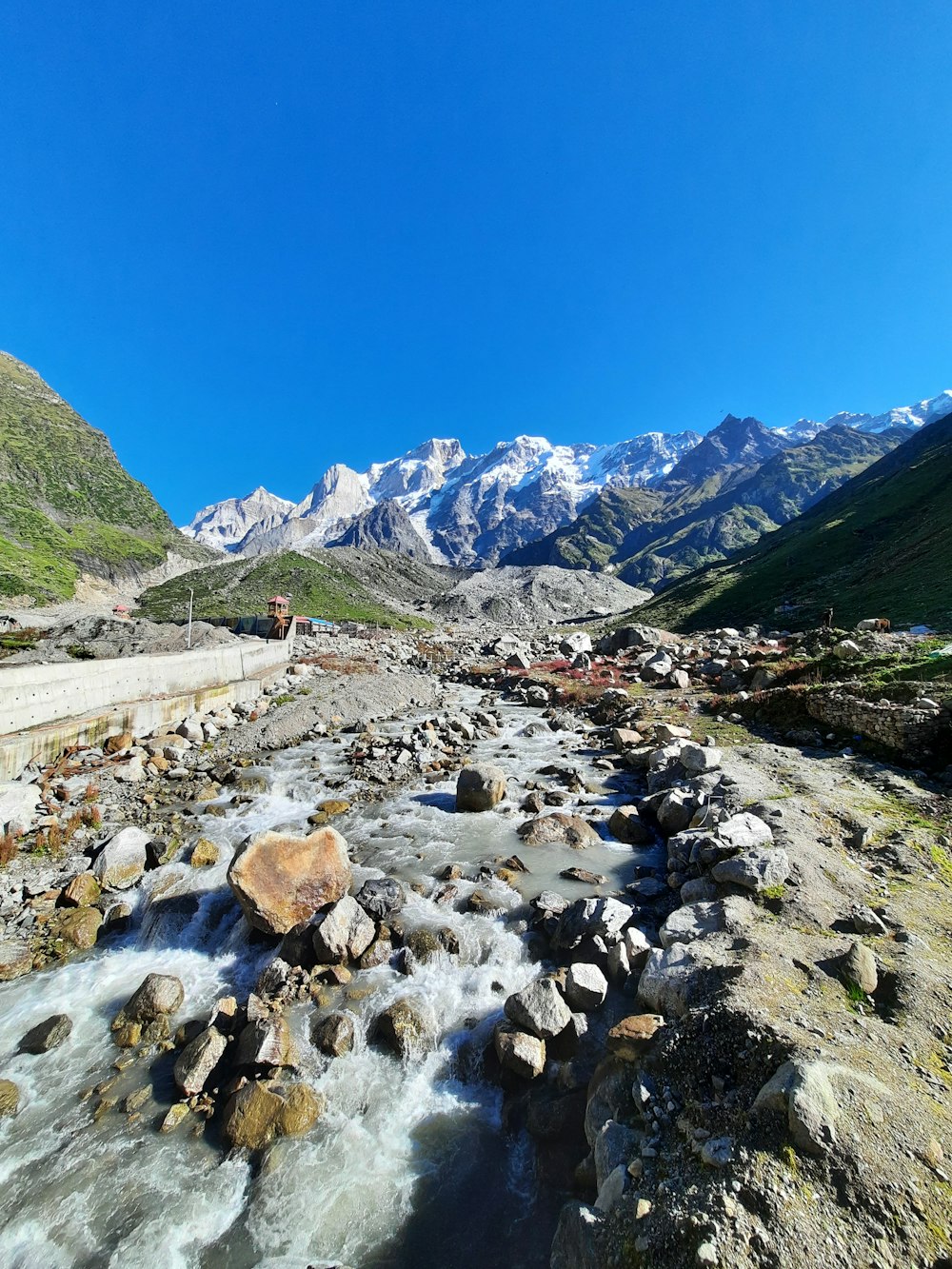 a river running through a valley with mountains in the background