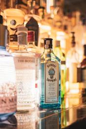A collection of premium liquors lined up with soft sky-blue lighting.