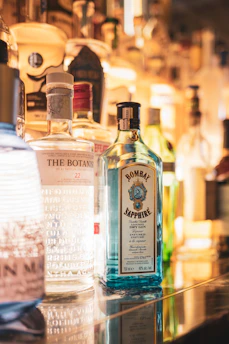 A collection of premium liquors lined up with soft sky-blue lighting.