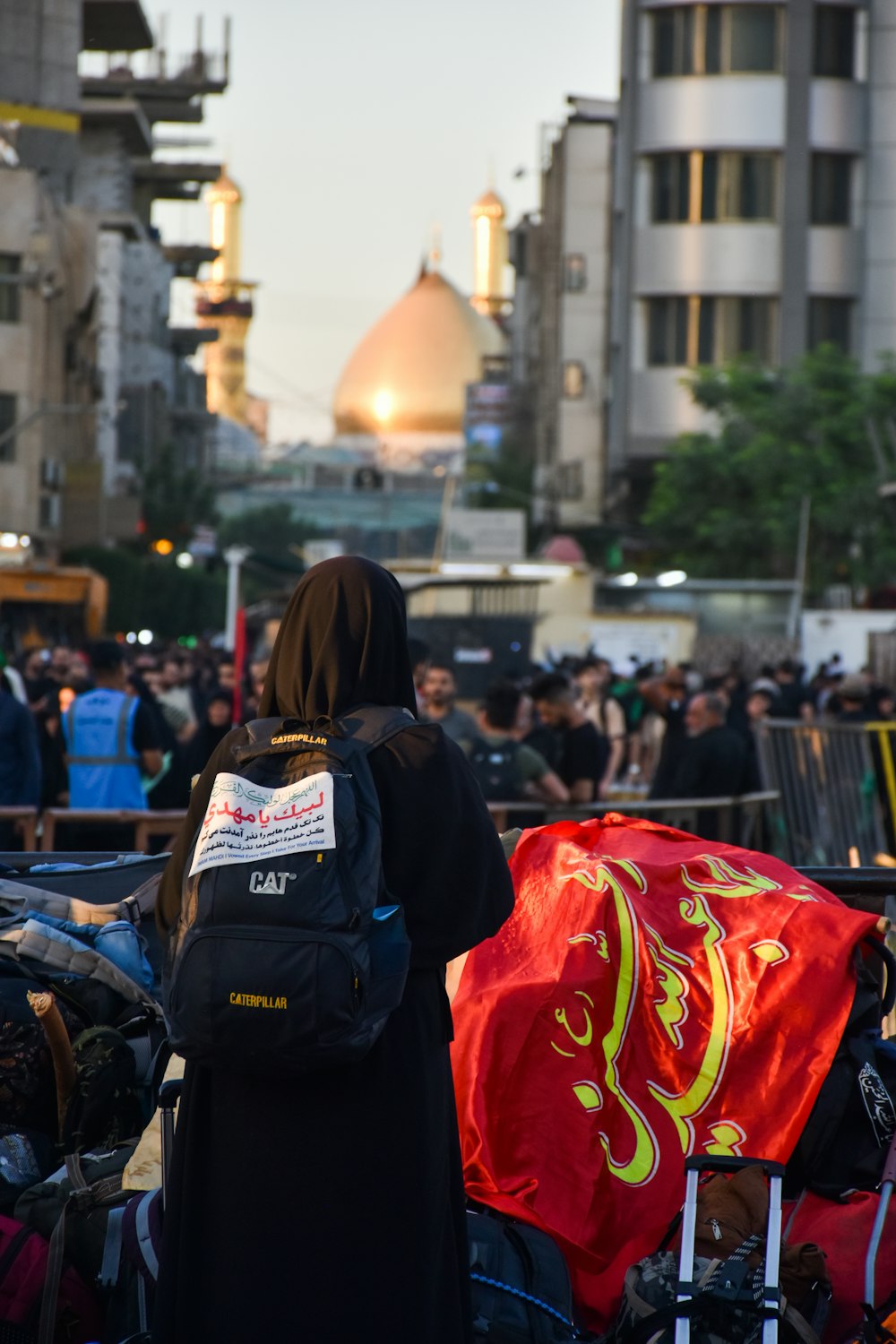 a person carrying a backpack walking down a street with a crowd of people