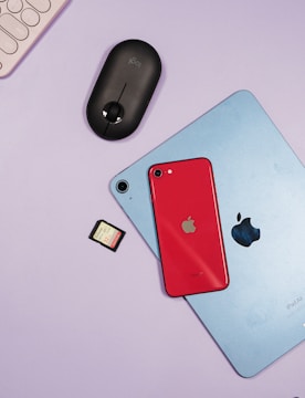 Minimalist flat lay of technology gadgets on desk with purple and green lights.