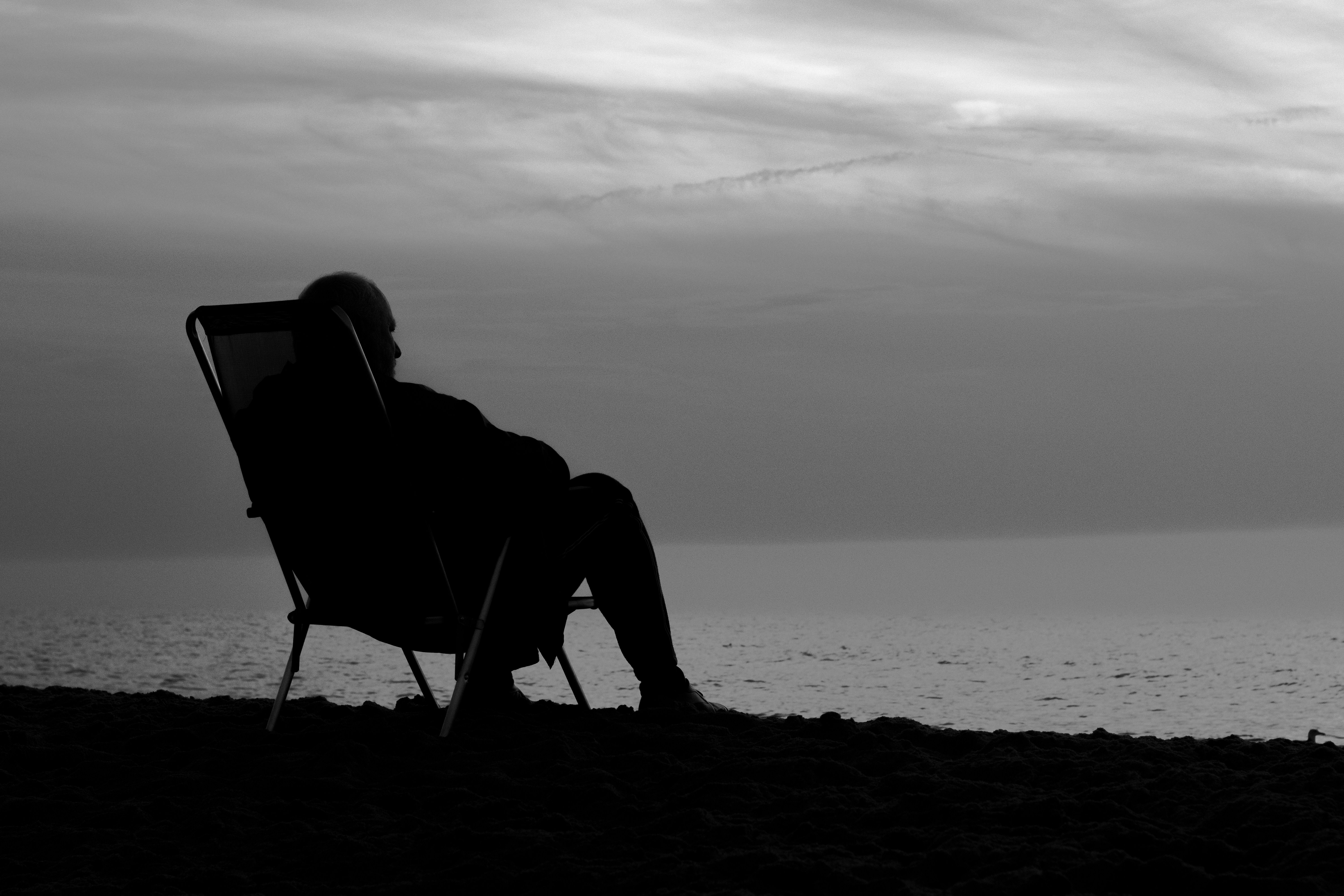 a person sitting in a chair on a beach