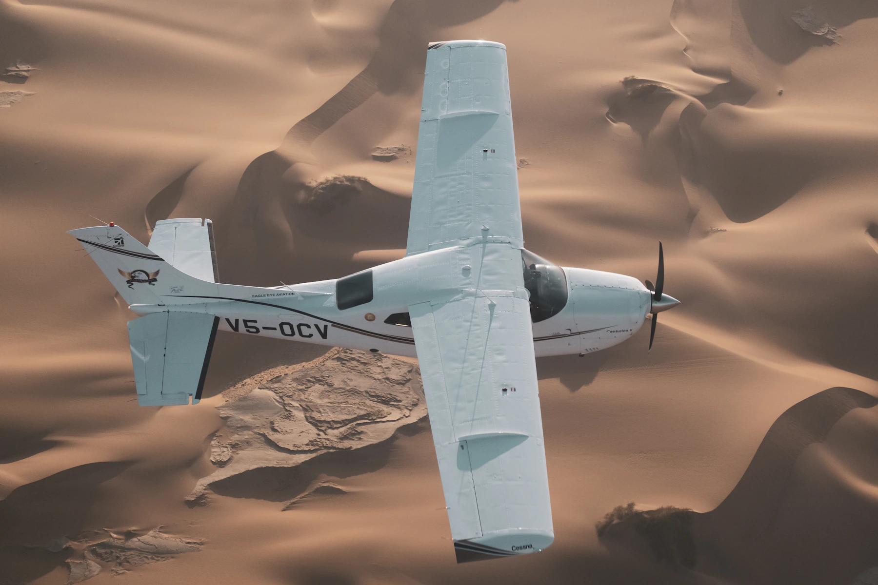A light aircraft flies above the Namib's sculpted dunes on a desert-and-coast circuit