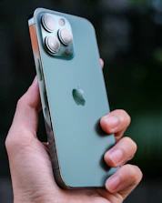 Close-up of a hand holding a smartphone displaying the Global TC7 app interface with green branding.