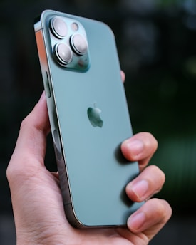 Close-up of a hand holding a shiny new smartphone with a vibrant screen.