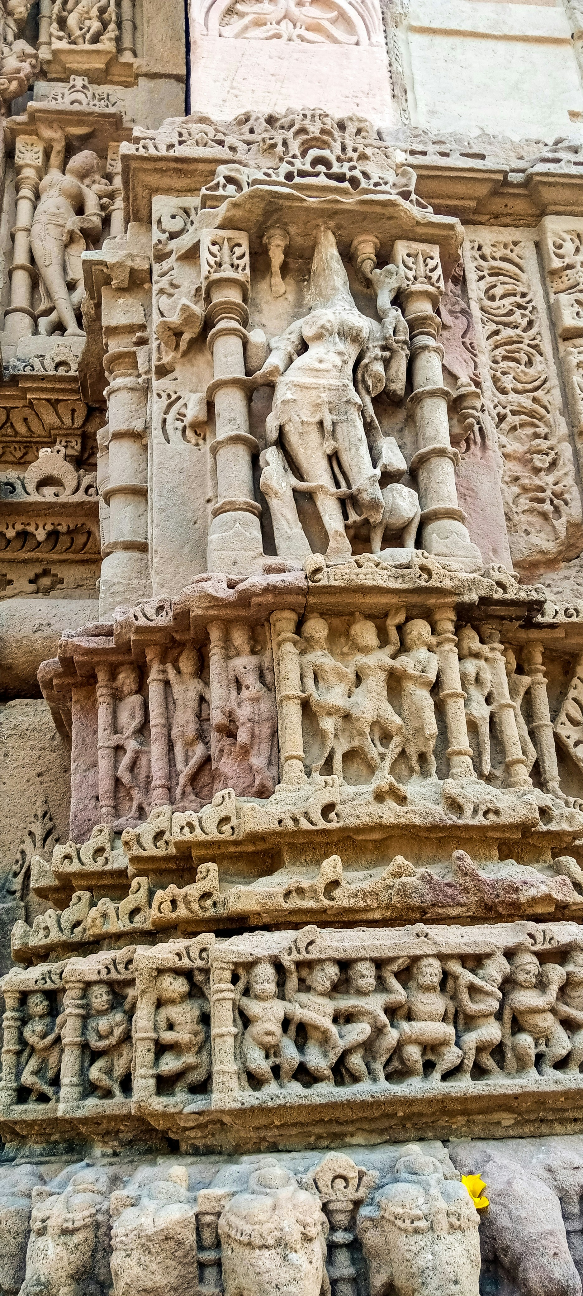 a stone building with carvings with Khajuraho Group of Monuments in the background