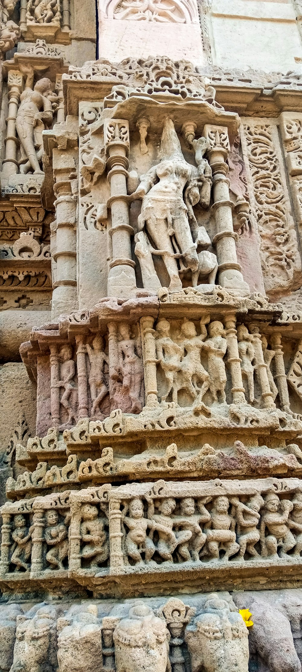 un bâtiment en pierre avec des sculptures avec le groupe de monuments de Khajuraho en arrière-plan