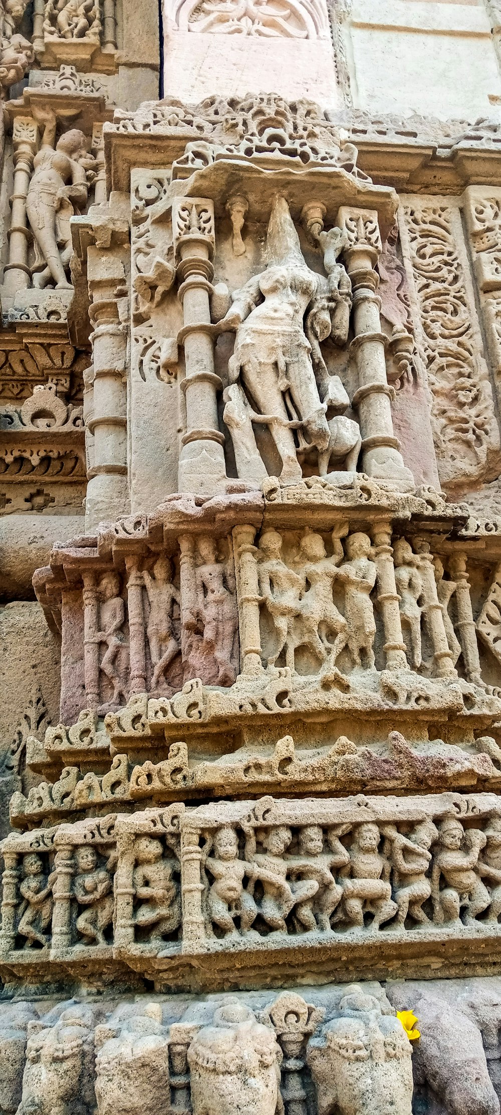 um edifício de pedra com esculturas com Khajuraho Grupo de Monumentos ao fundo