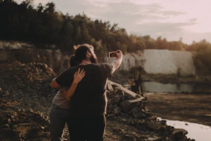 Close-up of a joyful couple capturing a selfie with the iconic Torres del Paine peaks behind them.