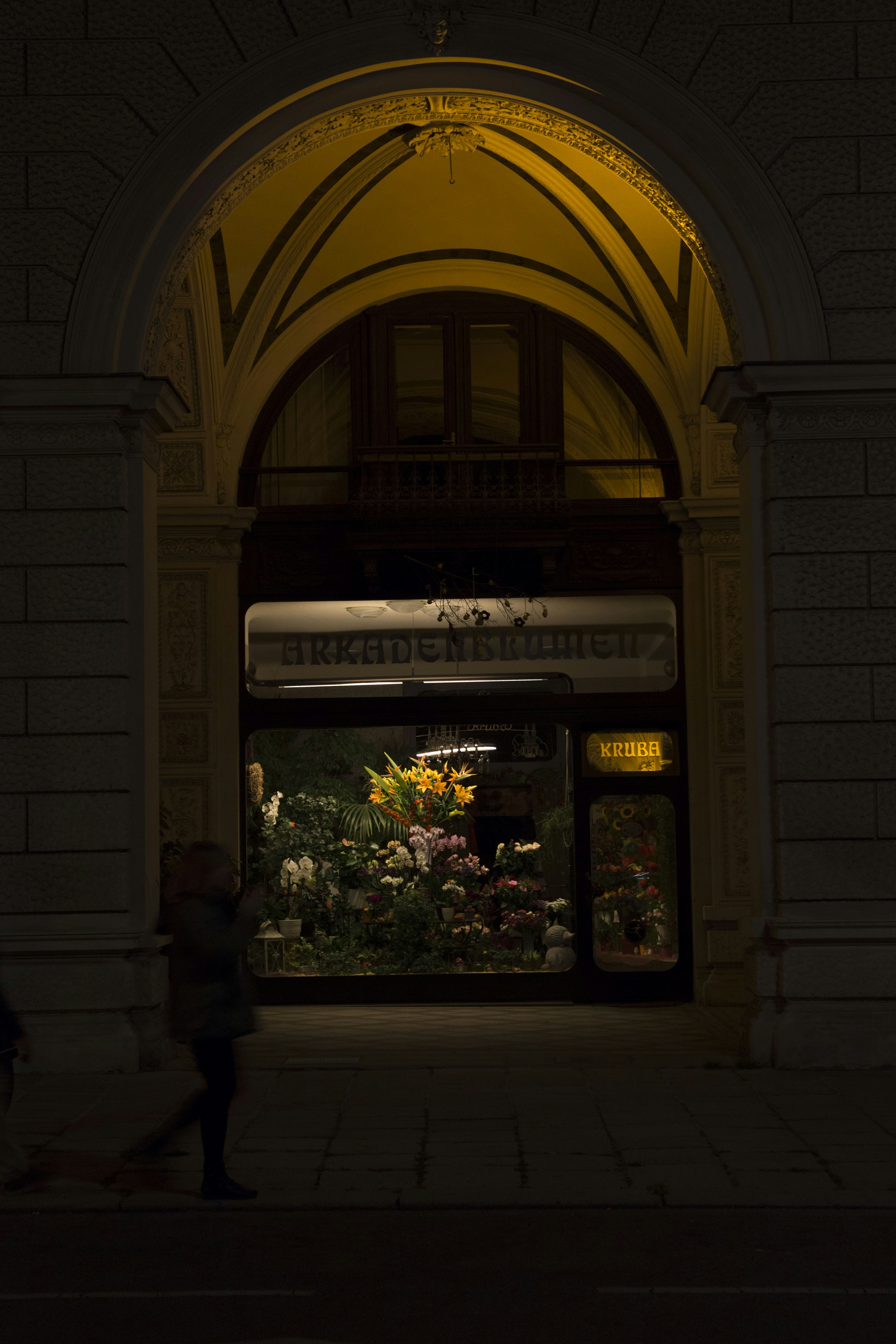 a person walking in front of a building with a large sign