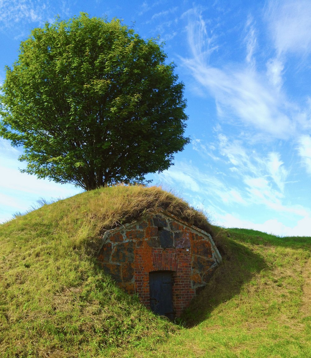 a brick building on a grassy hill