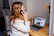 a woman sitting at a desk with a laptop and a phone