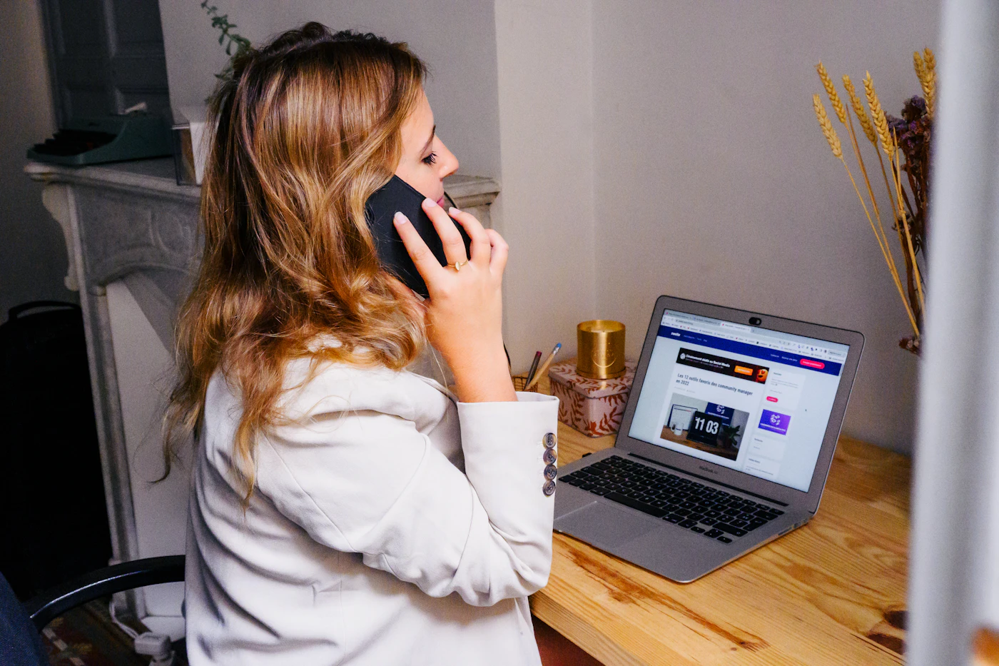 Sales professional making a call beside an open laptop