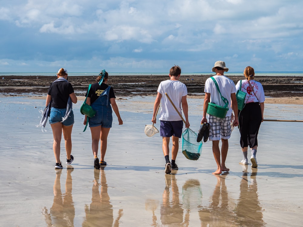 a group of people walking on a beach