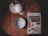 A wooden table holds a travel guidebook titled 'Morocco', featuring visuals of cultural landmarks. Beside it is a white bowl with a geometric pattern and a lamp with a perforated shade.