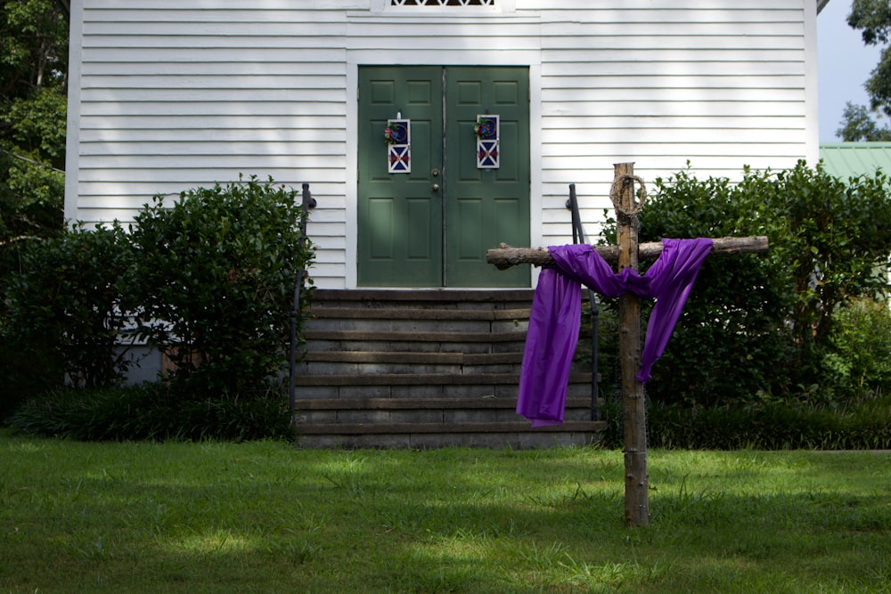 a person in a garment lying on a tree branch in front of a house