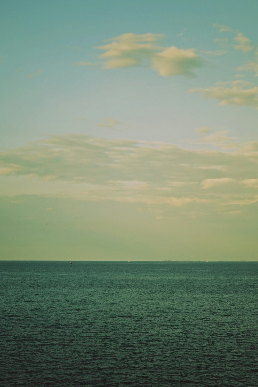 a body of water with a boat in it and a cloudy sky above