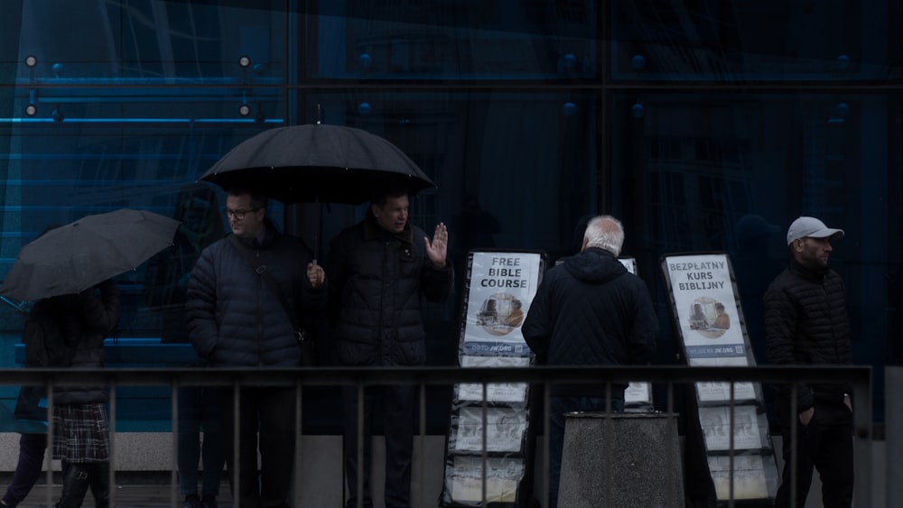 people standing under umbrellas