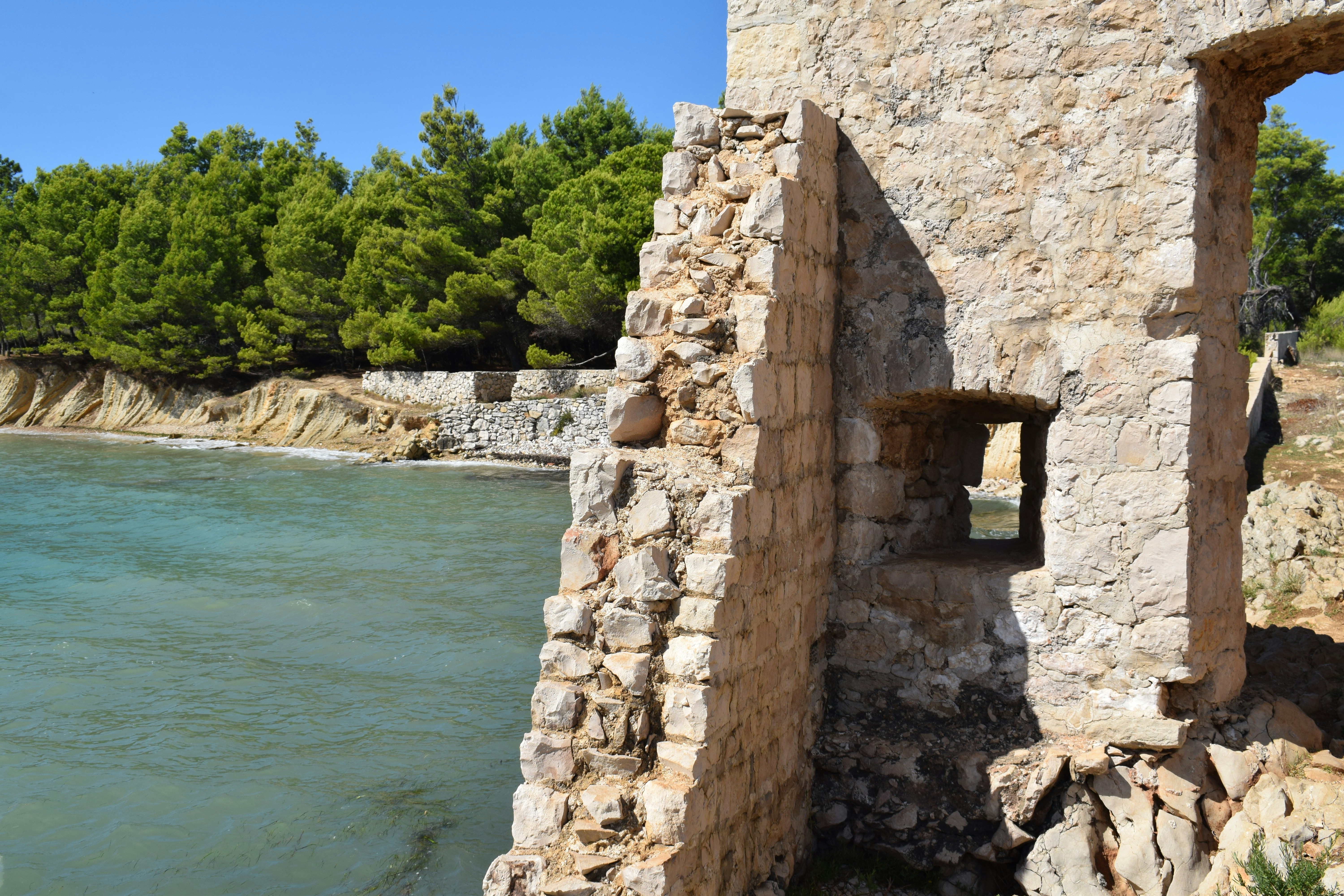 a stone building with a lake in the background