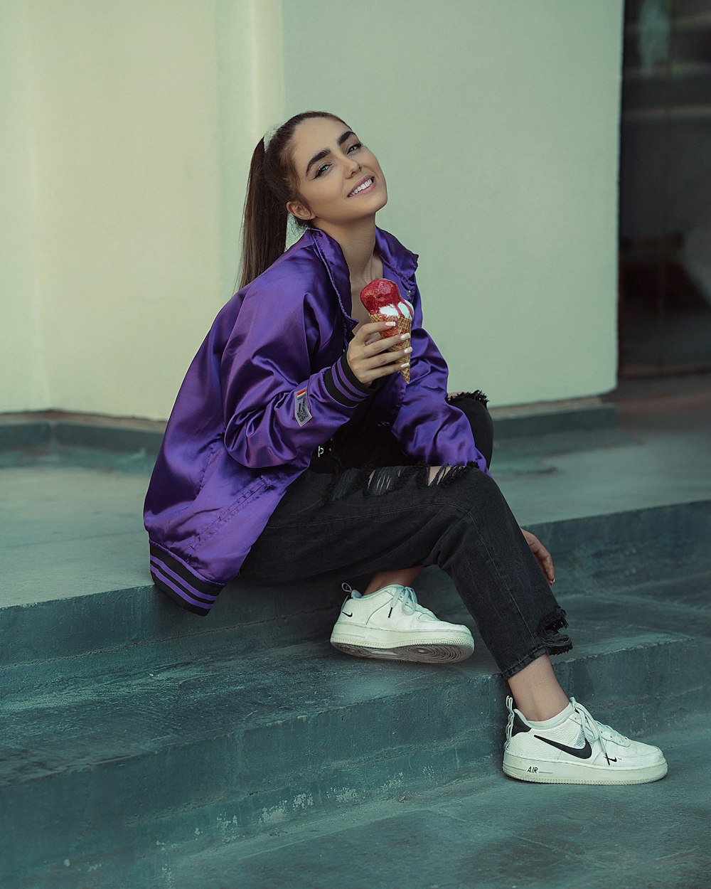 a woman sitting on the floor and holding a drink