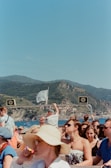 Tourists enjoying a sunny day on a boat, with clear blue waters around.