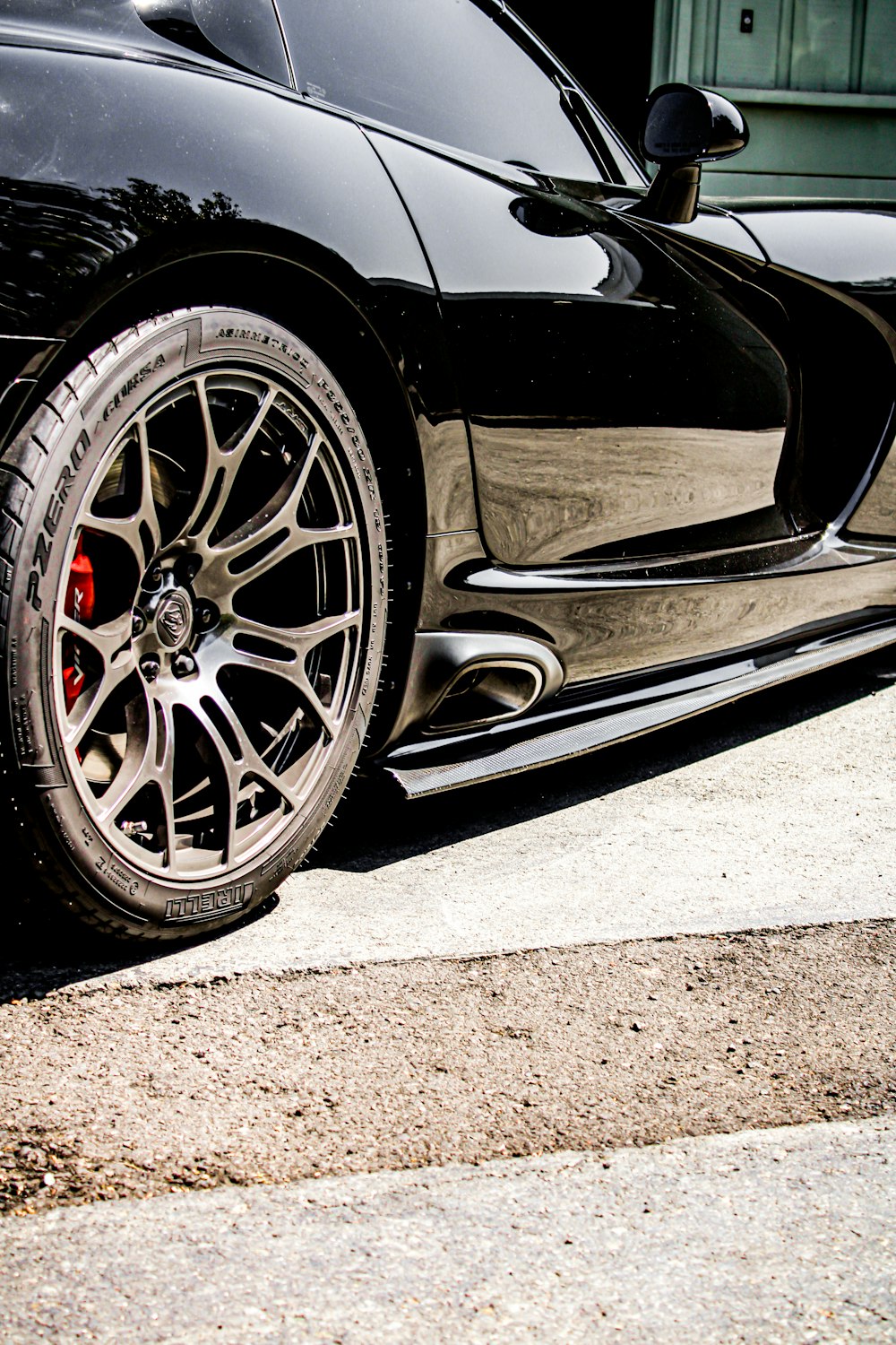 a black car with a dent in the front wheel