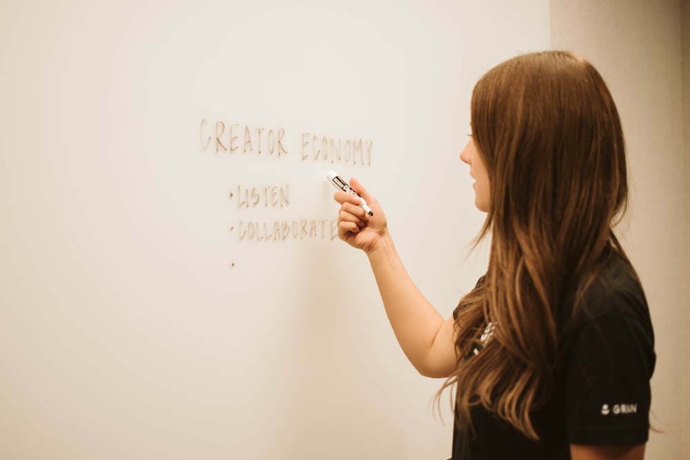 a woman writing on a whiteboard