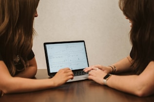 a woman and a girl using a laptop