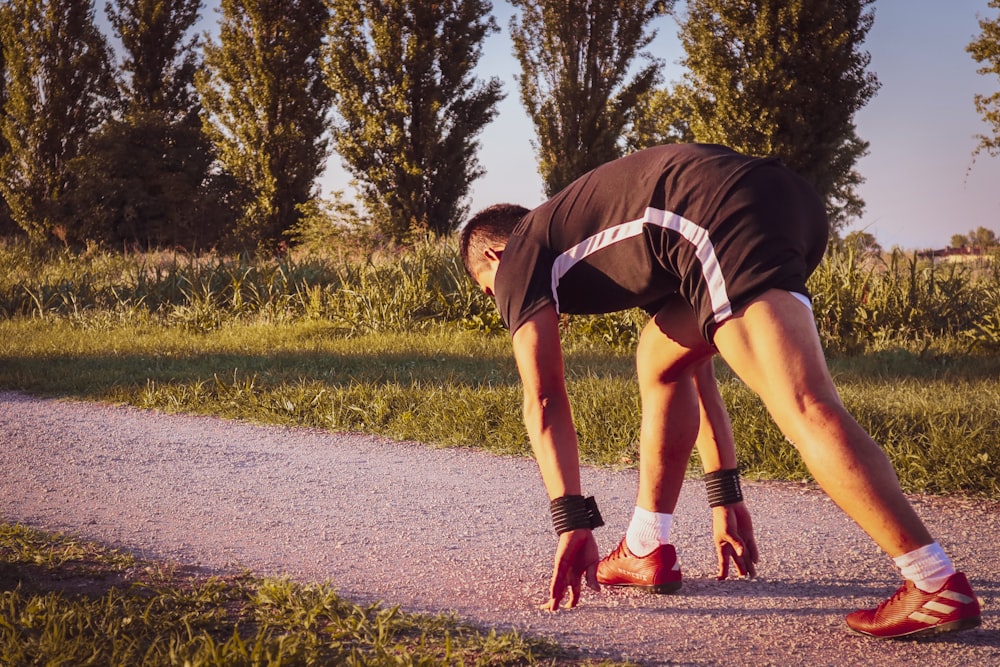 a person bending over on a road