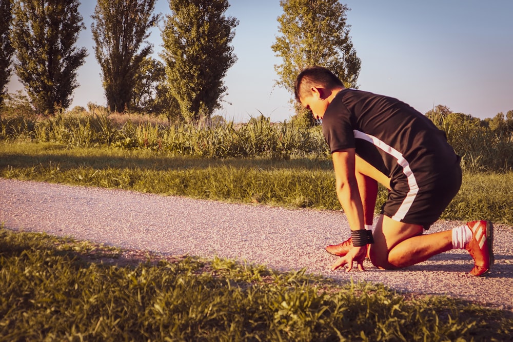 a man kneeling on a sidewalk