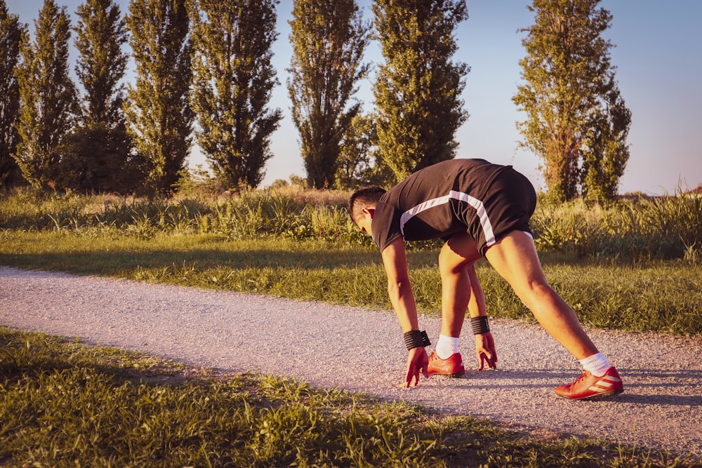 a man bending over on a road