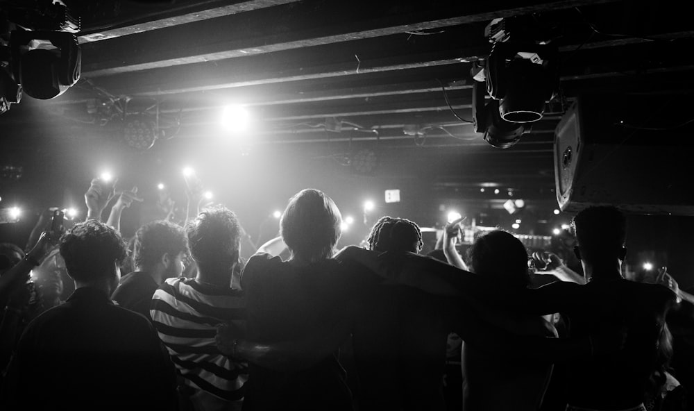 a group of people in a room with a stage and lights