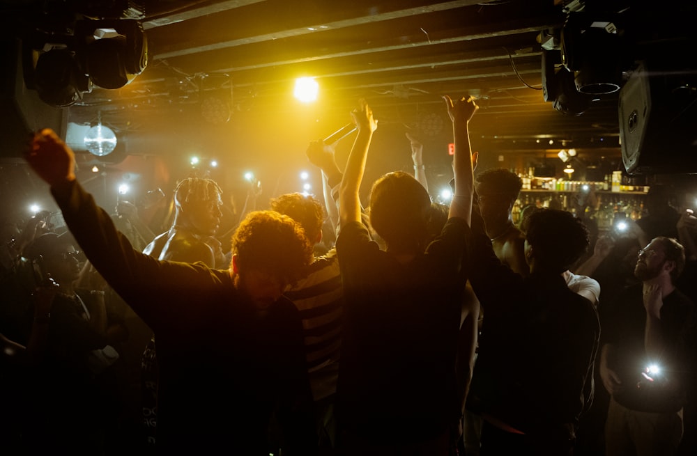 a group of people dancing in a dark room with lights