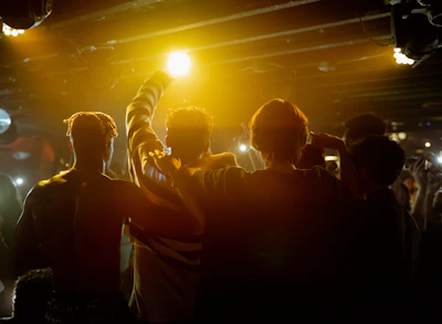 A lively crowd laughing and enjoying a standup comedy show under warm stage lights.