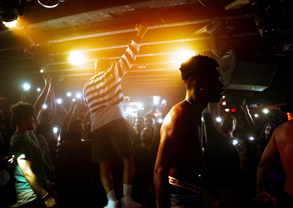 a man on a stage with a microphone and people around him