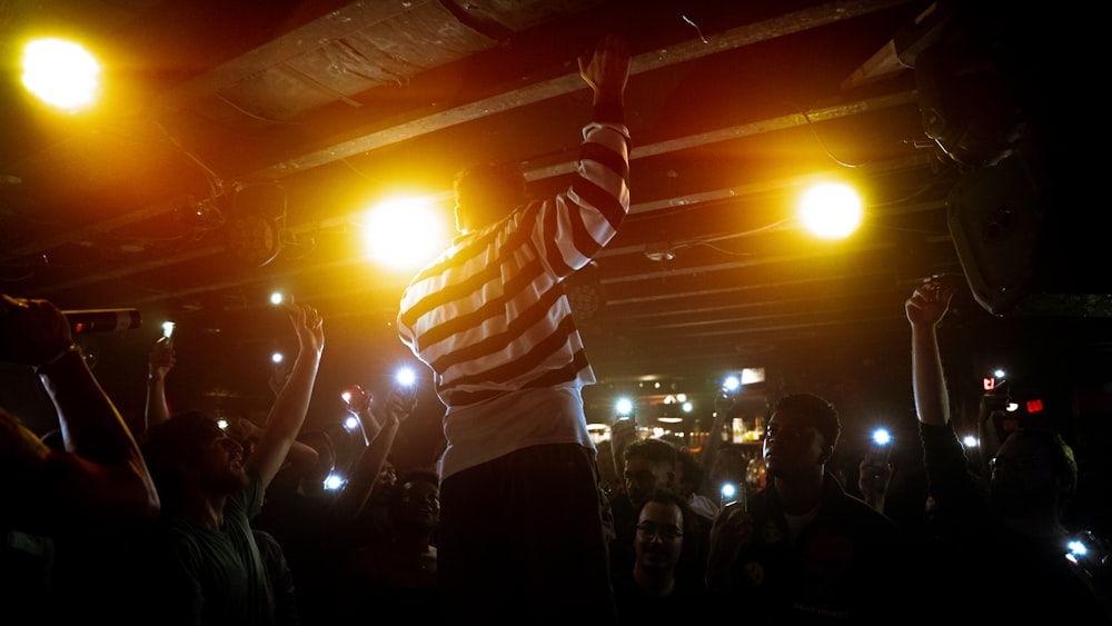 a person holding the hands up in front of a crowd of people