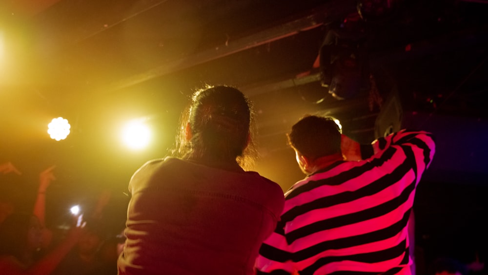 a group of people in a dark room with bright lights