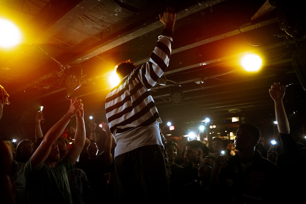 a man holding a microphone in front of a crowd of people