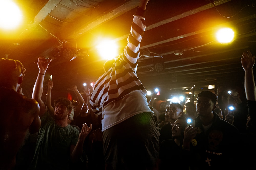 a person holding a microphone in front of a crowd of people